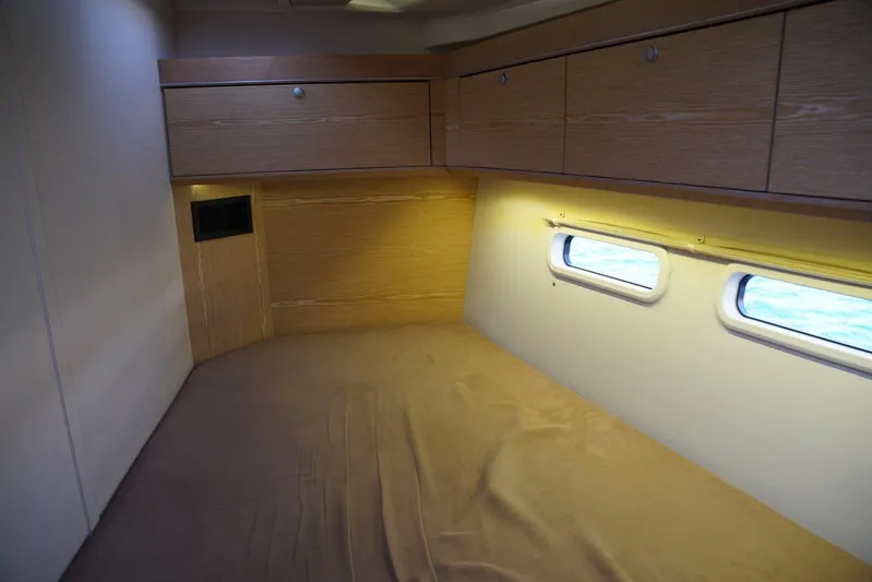  Yacht Photos Pics Interior cabin of 2013 Hanse 575 yacht with wooden cabinetry and porthole windows.