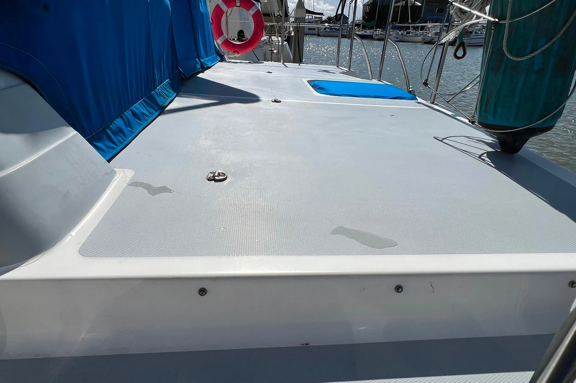 1989 Bayliner 4285 Avanti deck with blue cover and life preserver, docked at marina.