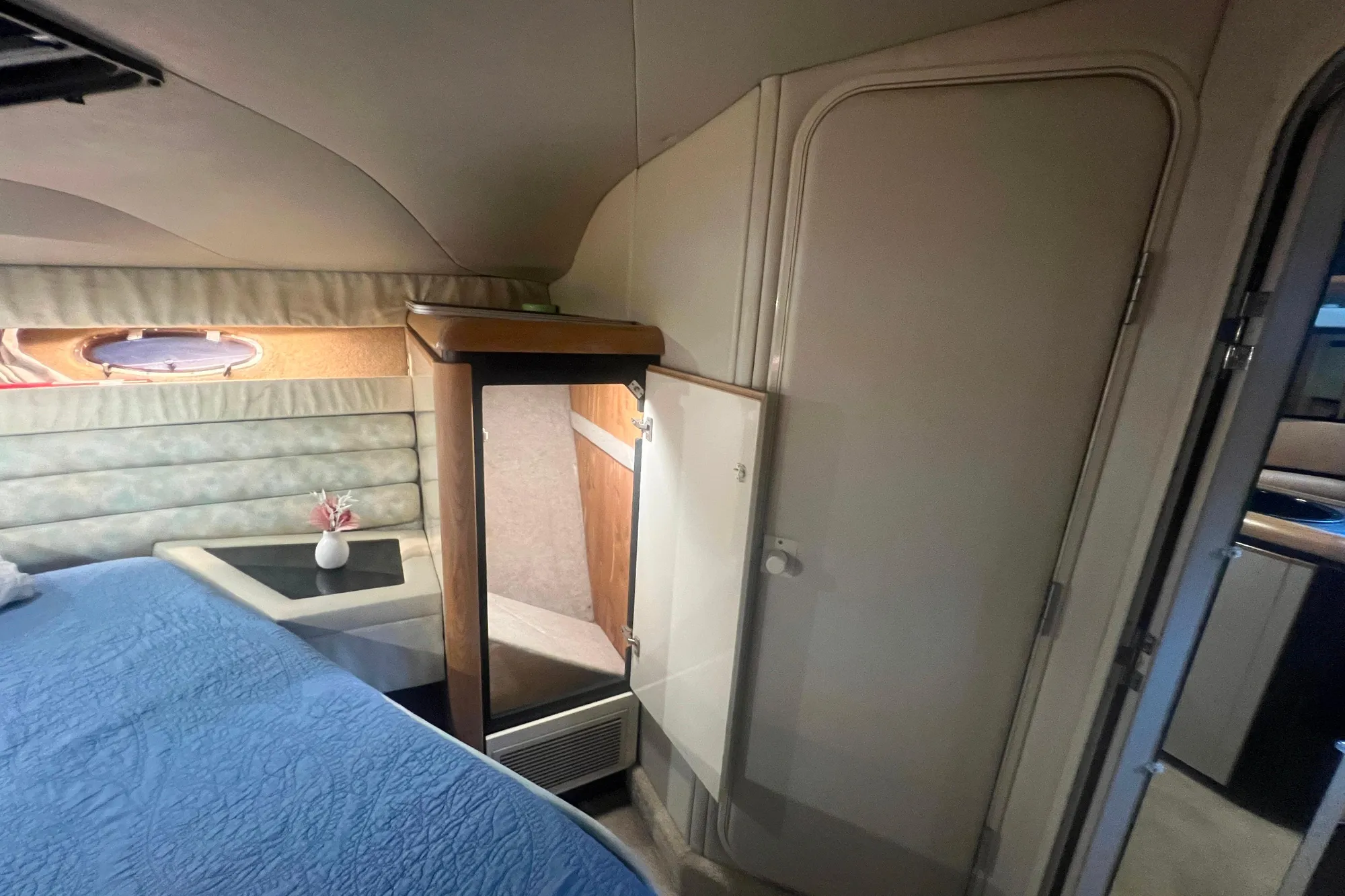 1989 Bayliner 4285 Avanti cabin interior with bed, mirror, and small table.