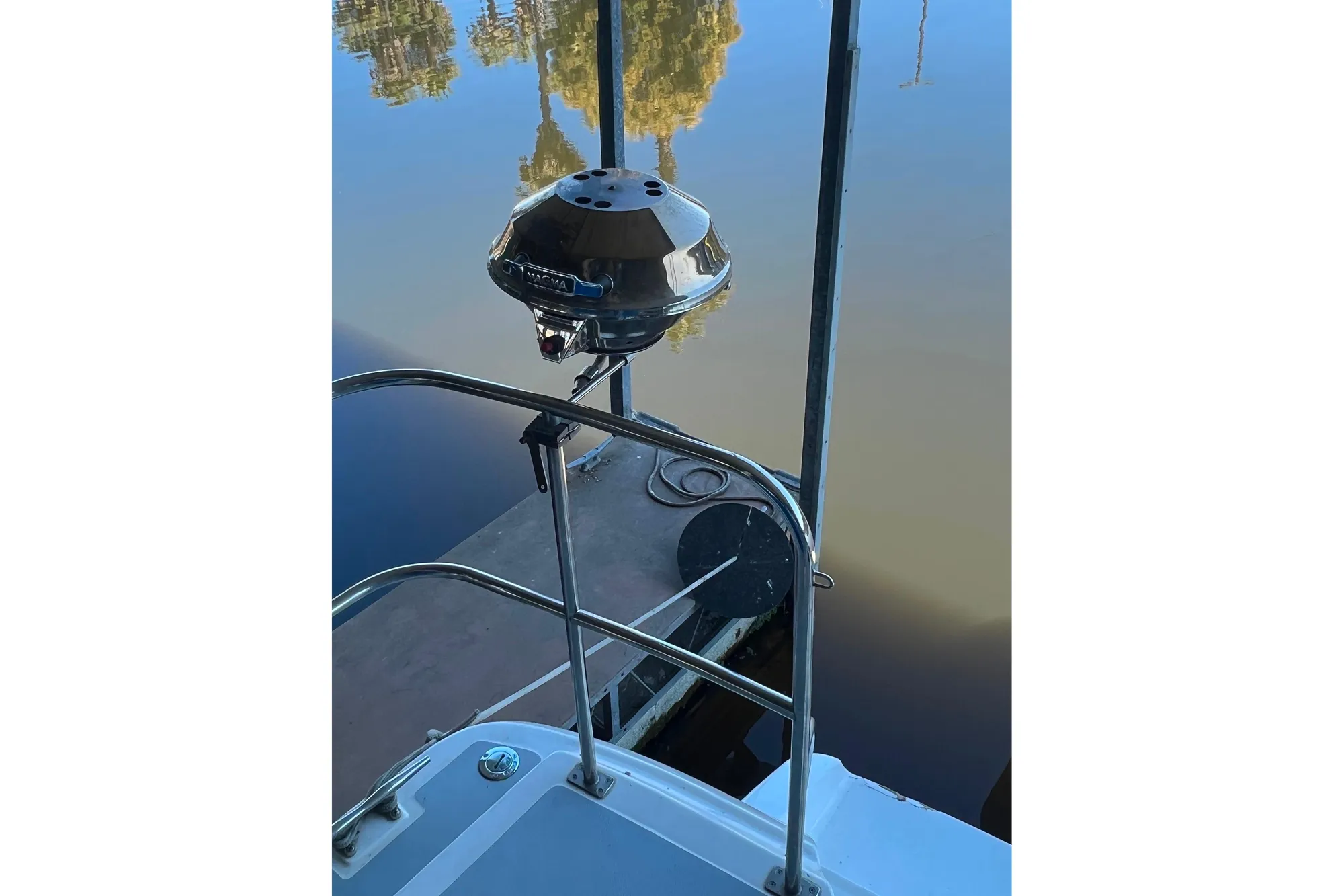 1989 Bayliner 4285 Avanti boat with a mounted grill by the water.