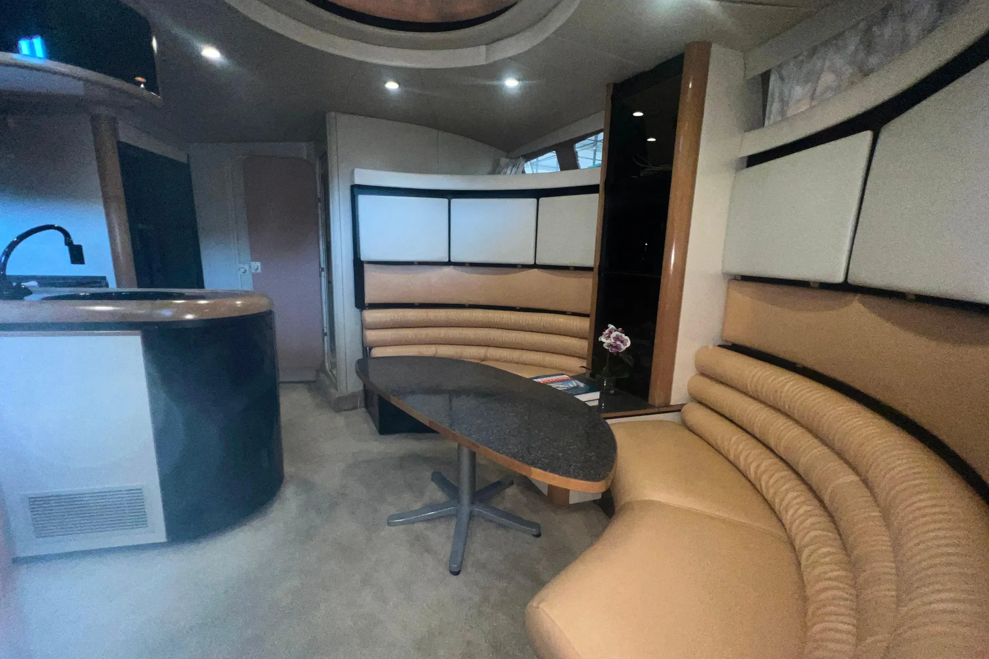 Interior of 1989 Bayliner 4285 Avanti yacht with curved seating and table.