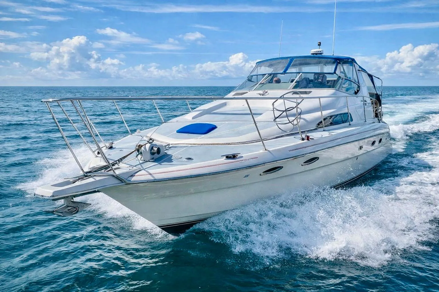 1989 Bayliner 4285 Avanti cruising on open water under a clear blue sky.