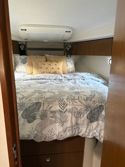 Jac & Wood Yacht Photos Pics Cozy bedroom in 2017 Cruisers Yachts 380 Express with floral bedding and wooden cabinetry.