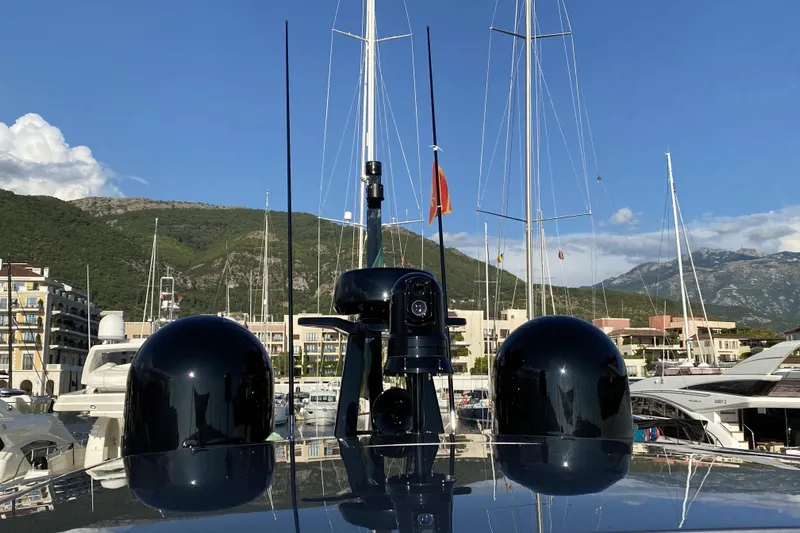  Yacht Photos Pics 2023 Pershing 6X yacht docked in a scenic marina with mountains in the background.