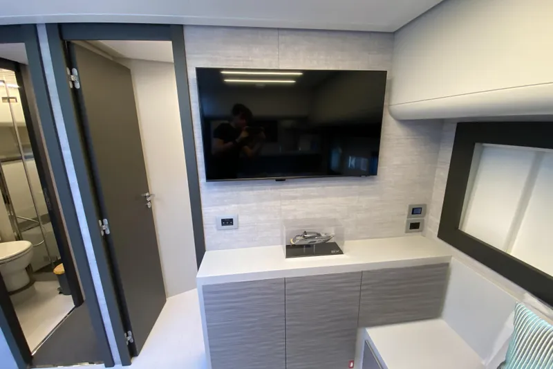  Yacht Photos Pics Modern interior of 2023 Pershing 6X yacht with TV and sleek cabinetry.