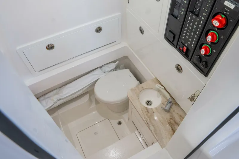 T/t Silvertime Yacht Photos Pics 2023 Valhalla Boatworks V-33 interior bathroom with toilet, sink, and control panel.