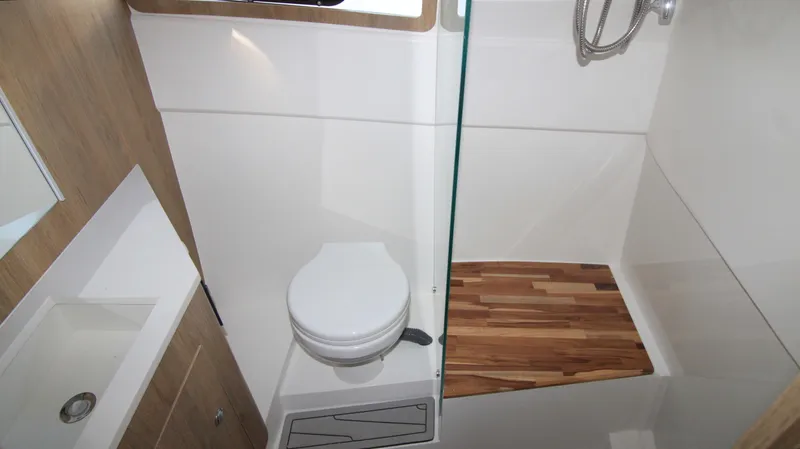  Yacht Photos Pics 2023 NX Boats 34 Sport Coupe bathroom with modern fixtures and wooden shower floor.