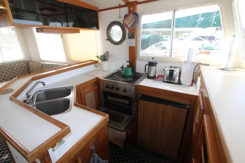 Adria Yacht Photos Pics Cozy kitchen in 2000 Willard Marine 40 Flybridge Sedan Trawler with stove, sink, and appliances.