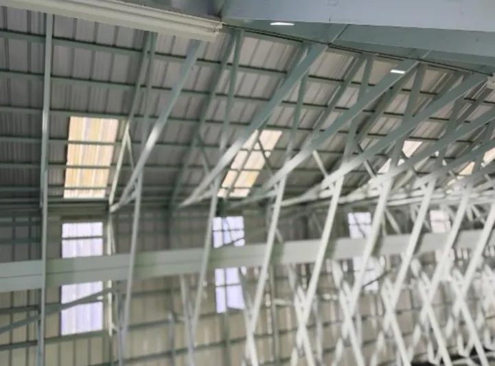  Yacht Photos Pics Interior view of a custom boathouse roof structure, 2017, featuring metal beams and skylights.