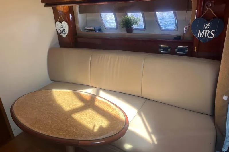  Yacht Photos Pics Luxurious interior of 2012 Sea Ray 390 Sundancer with beige seating and wooden table.