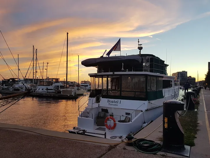 Boatel I Yacht Photos Pics Custom 65 Foot Trawler docked at sunset, 1998 model, with vibrant sky and marina backdrop.