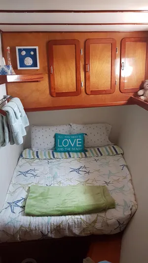 Boatel I Yacht Photos Pics Cozy bedroom in a 1998 Custom 65 Foot Trawler with nautical decor and wooden cabinets.
