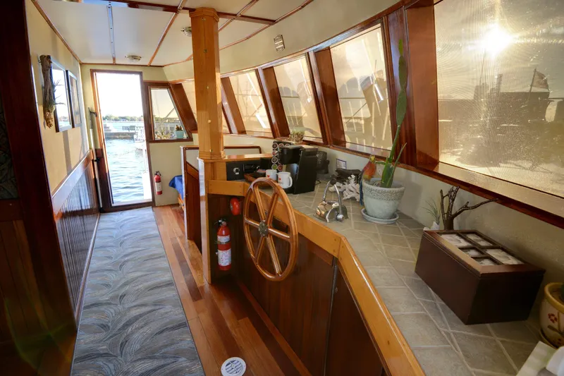 Boatel I Yacht Photos Pics Interior of a 1998 Custom 65 Foot Trawler with wooden helm and panoramic windows.