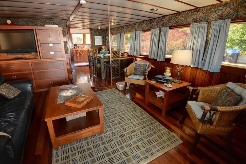 Boatel I Yacht Photos Pics Interior of a 1998 Custom 65 Foot Trawler with cozy seating and wooden decor.