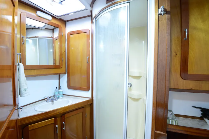 Boatel I Yacht Photos Pics Bathroom interior of a 1998 Custom 65 Foot Trawler with wooden cabinets and shower.