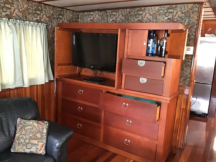 Boatel I Yacht Photos Pics Interior of a 1998 Custom 65 Foot Trawler with wooden cabinetry and TV.