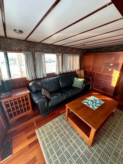 Boatel I Yacht Photos Pics Luxurious interior of a 1998 Custom 65 Foot Trawler with leather sofa and wooden furnishings.
