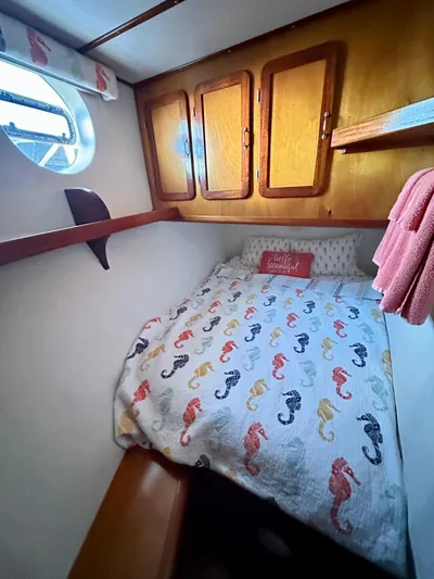 Boatel I Yacht Photos Pics Cozy cabin bedroom in a 1998 custom 65-foot trawler with seahorse-themed bedding.