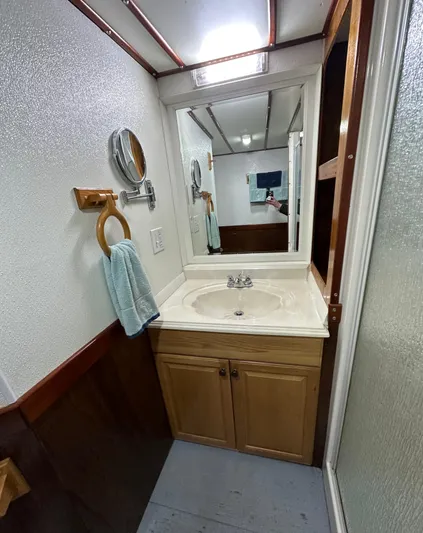 Boatel I Yacht Photos Pics Bathroom interior of a 1998 Custom 65 Foot Trawler with sink, mirror, and towel.