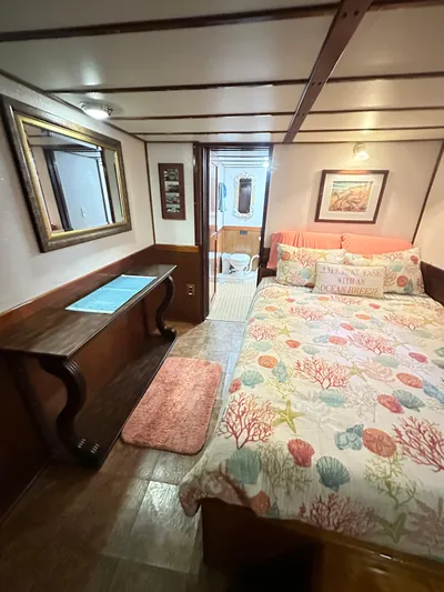 Boatel I Yacht Photos Pics Cozy bedroom in a 1998 custom 65-foot trawler with nautical-themed decor.