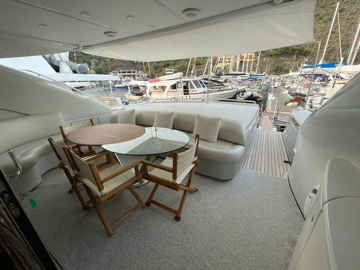  Yacht Photos Pics Luxury yacht deck with seating and table, Pershing 76, 2005 model, docked in marina.