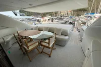 Luxury yacht deck with seating and table, Pershing 76, 2005 model, docked in marina.