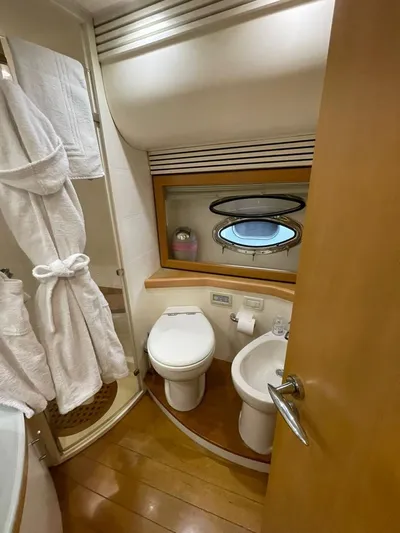  Yacht Photos Pics Luxurious bathroom on 2005 Pershing 76 yacht with modern amenities and porthole window.