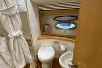 Luxurious bathroom on 2005 Pershing 76 yacht with modern amenities and porthole window.