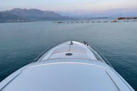 Bow view of 2005 Pershing 76 yacht on calm sea with distant mountains.