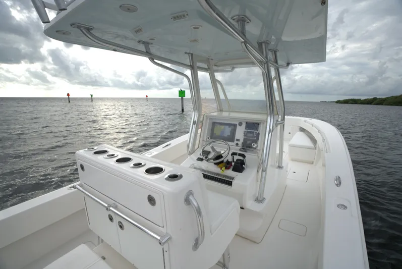  Yacht Photos Pics Invincible 33 boat from 2012 on open water, featuring a sleek console and navigation equipment.