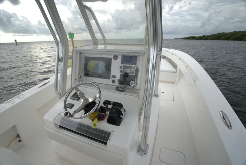  Yacht Photos Pics Invincible 33 boat console, 2012 model, on calm waters under cloudy skies.