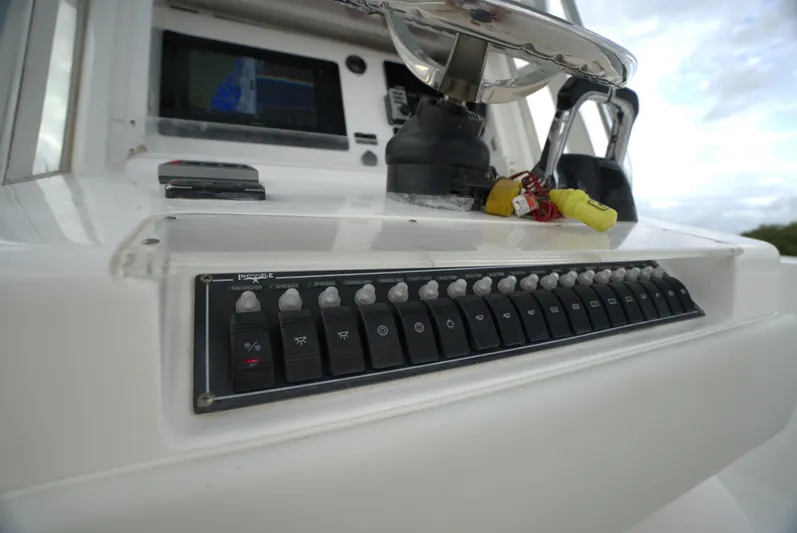  Yacht Photos Pics Control panel of 2012 Invincible 33 boat with switches and steering wheel.