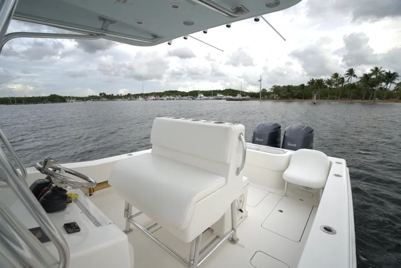  Yacht Photos Pics Invincible 33 boat interior, 2012 model, with dual engines on a calm water backdrop.