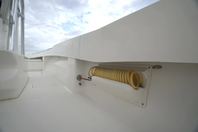  Yacht Photos Pics Invincible 33 boat deck with coiled hose, 2012 model, under cloudy sky.