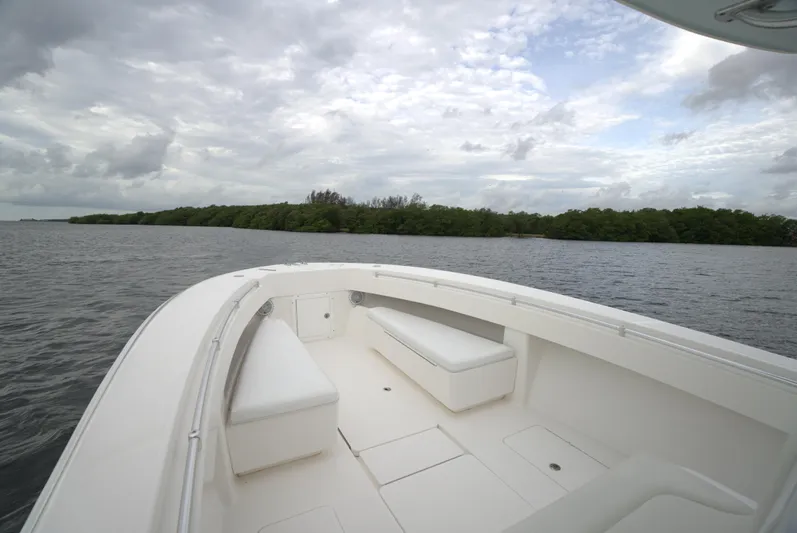  Yacht Photos Pics Invincible 33 boat, 2012 model, cruising on a calm lake under cloudy skies.