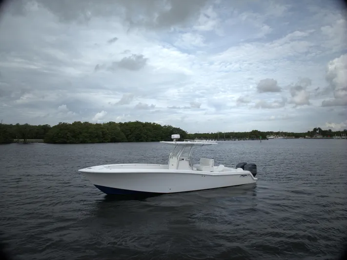  Yacht Photos Pics 2012 Invincible 33 boat on calm water under cloudy sky.
