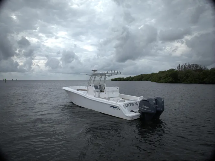  Yacht Photos Pics Invincible 33 boat on water, cloudy sky, 2012 model.