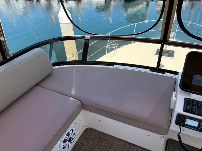  Yacht Photos Pics Interior view of 2014 Carver C34 yacht with cushioned seating and marina backdrop.