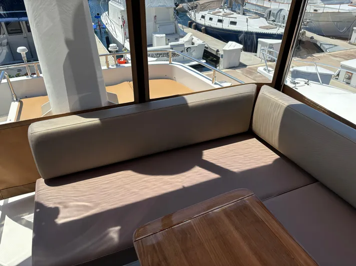  Yacht Photos Pics Interior view of a 2014 Carver C34 yacht with comfortable seating and marina background.