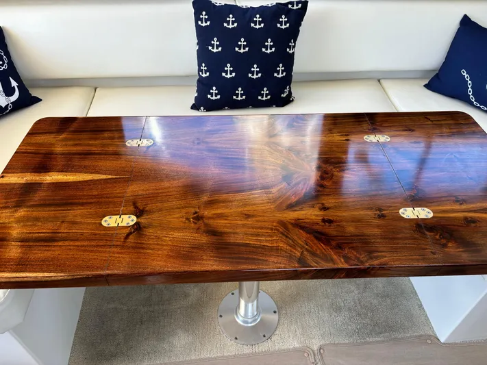  Yacht Photos Pics Luxurious wooden table on 2014 Carver C34 yacht, with nautical-themed cushions.