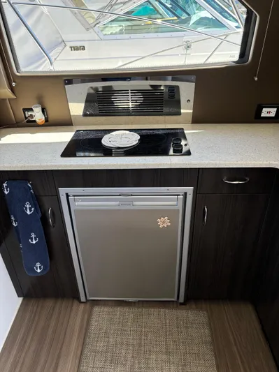  Yacht Photos Pics 2014 Carver C34 yacht kitchen with stove, fridge, and nautical decor.