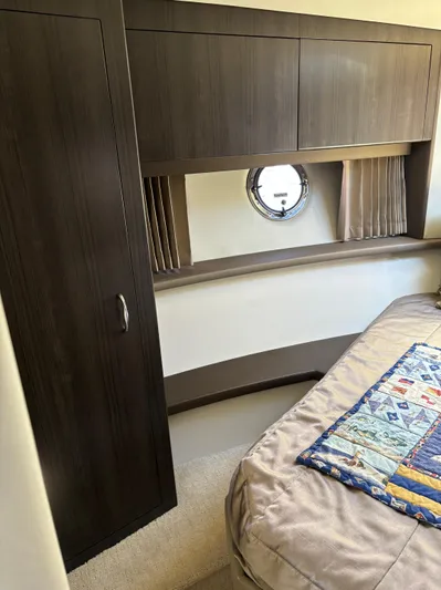  Yacht Photos Pics 2014 Carver C34 cabin interior with wood cabinetry and porthole window.