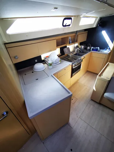 Blue Tide Yacht Photos Pics Modern kitchen interior of 2020 Beneteau Oceanis 46.1 yacht, featuring sleek cabinetry and appliances.
