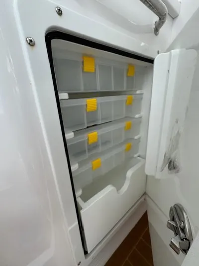  Yacht Photos Pics 2023 Southport 33 DC boat storage compartment with organized shelves and yellow accents.