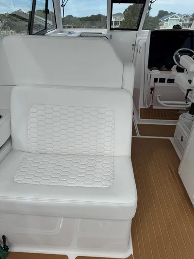  Yacht Photos Pics 2023 Southport 33 DC boat interior with white seating and wood-style flooring.