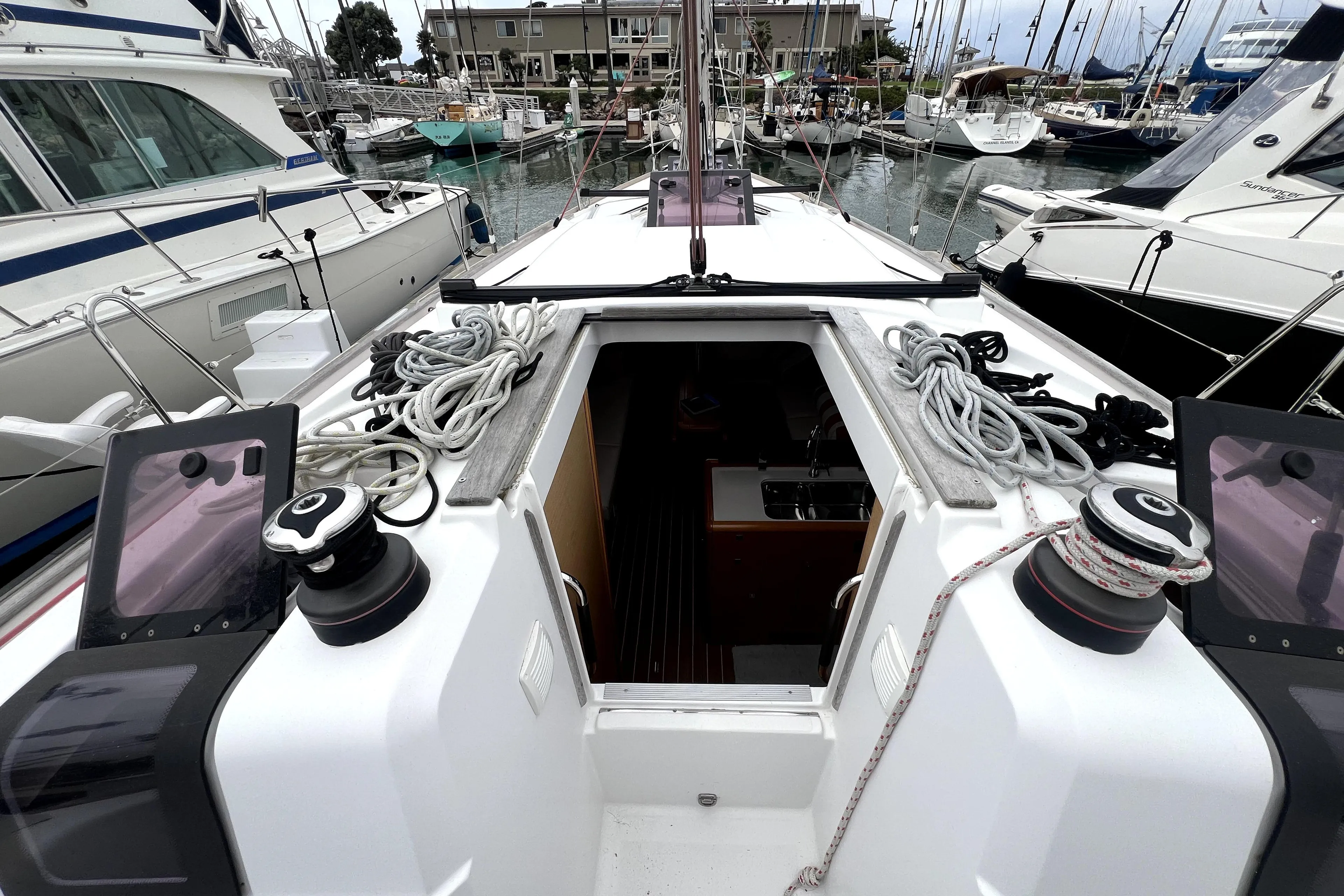 2014 Jeanneau Sun Odyssey 379 sailboat deck with ropes and winches in marina.