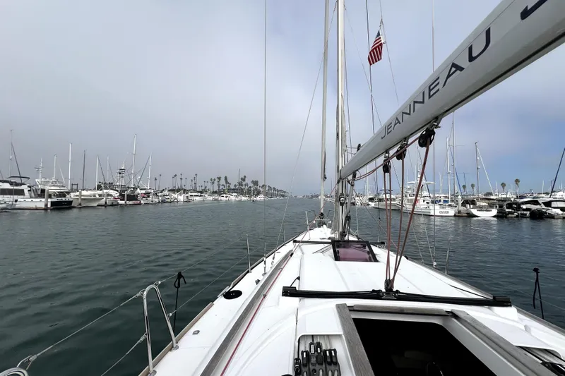 Knot Behaving Yacht Photos Pics 2014 Jeanneau Sun Odyssey 379 sailboat docked in a marina, surrounded by other boats.