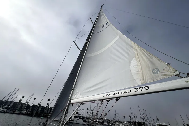 Knot Behaving Yacht Photos Pics Sailboat Jeanneau Sun Odyssey 379, 2014 model, with sails unfurled in a marina.