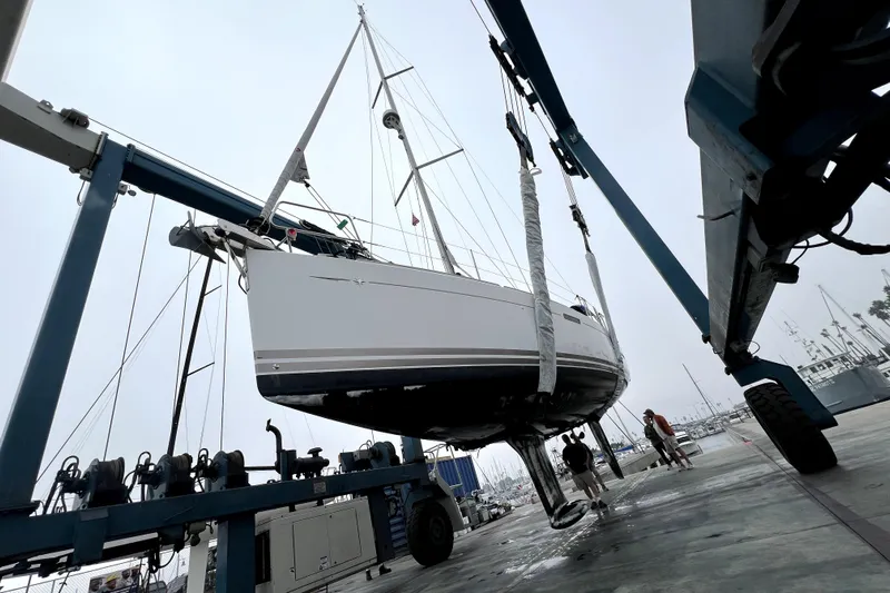 Knot Behaving Yacht Photos Pics 2014 Jeanneau Sun Odyssey 379 sailboat being lifted in a marina.