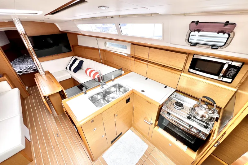Knot Behaving Yacht Photos Pics Interior of 2014 Jeanneau Sun Odyssey 379 sailboat with modern kitchen and seating area.